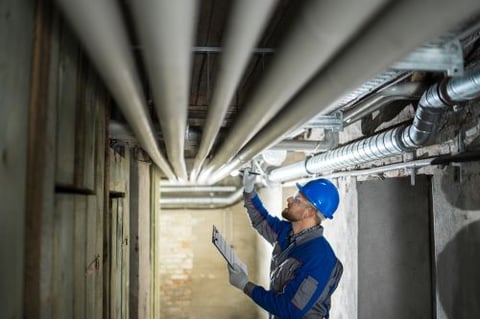 Man inspecting water pipes for leaks